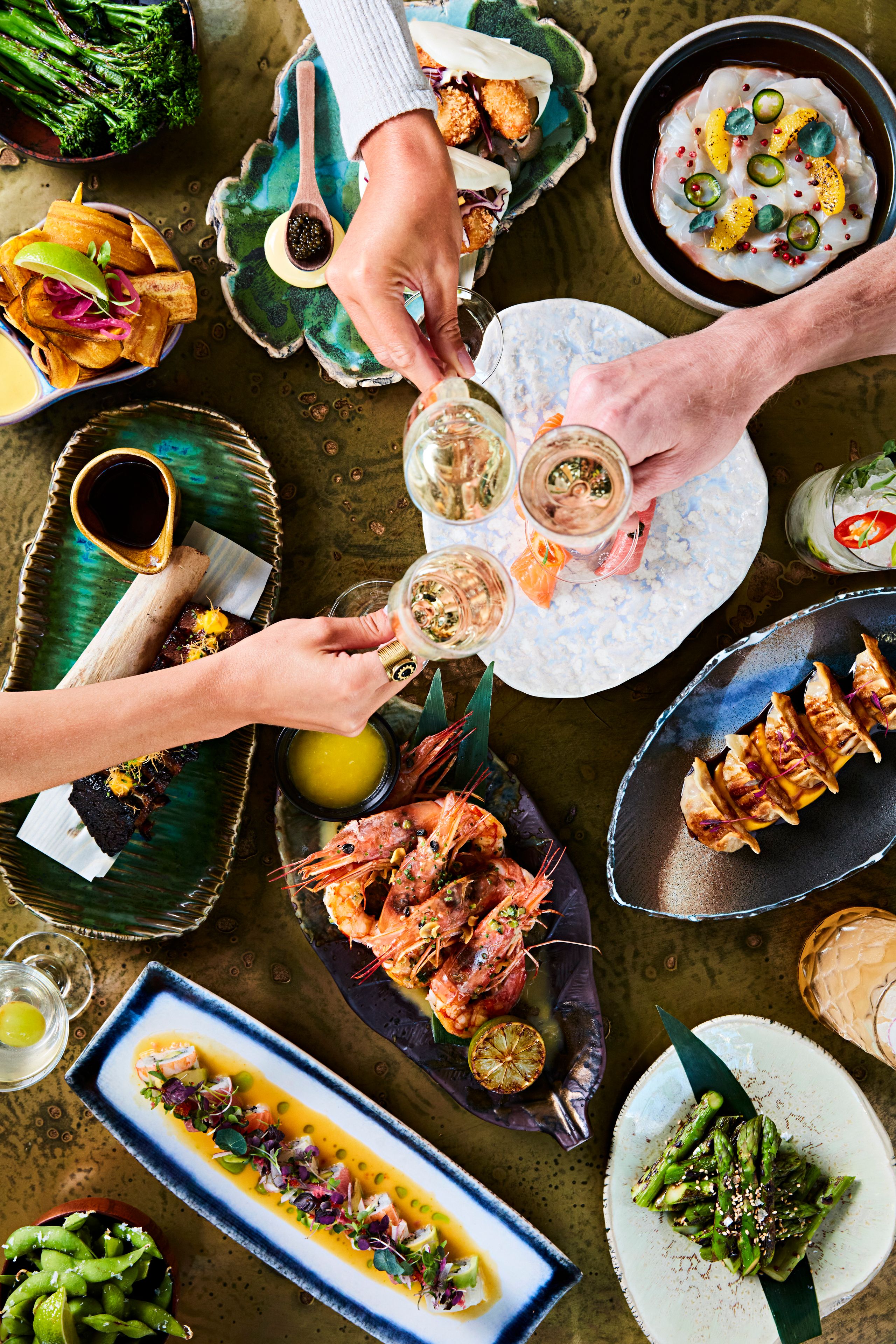SUSHISAMBA menu with variety of dishes and guests toasting